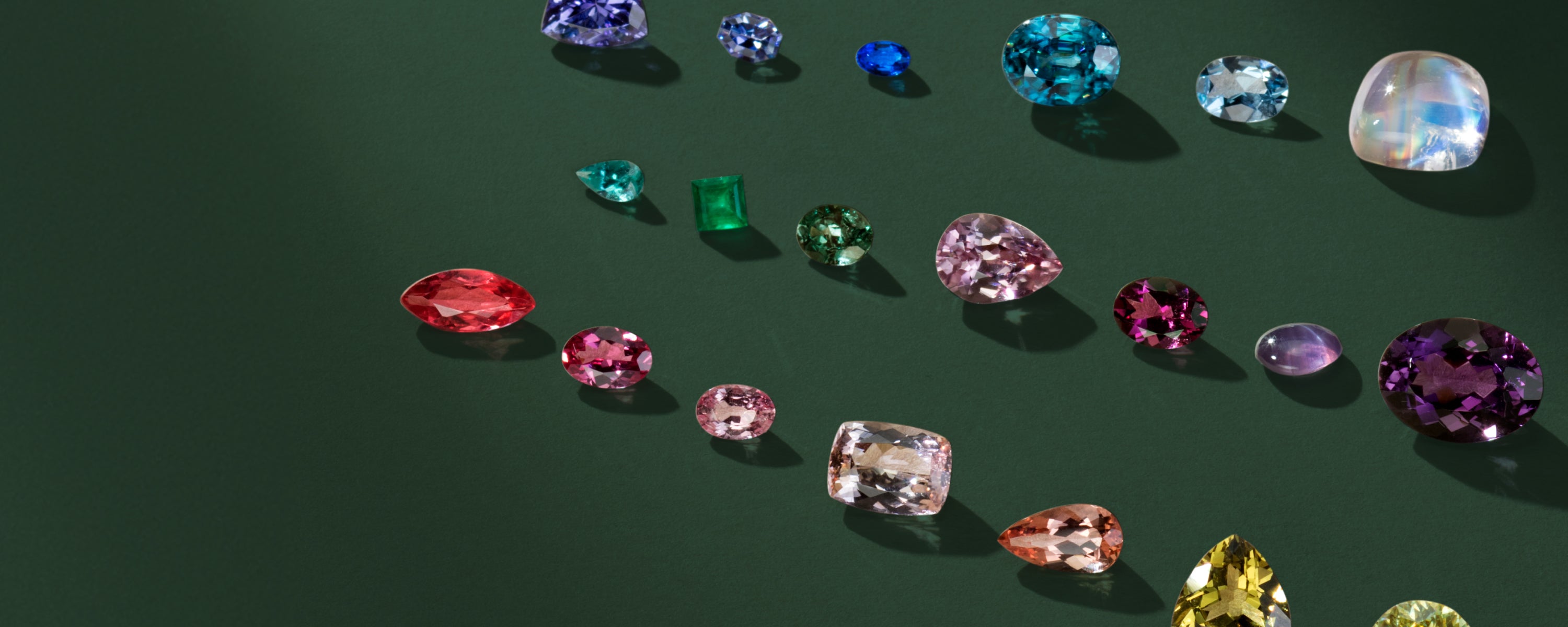 A variety of colorful gemstones arranged on a dark background.